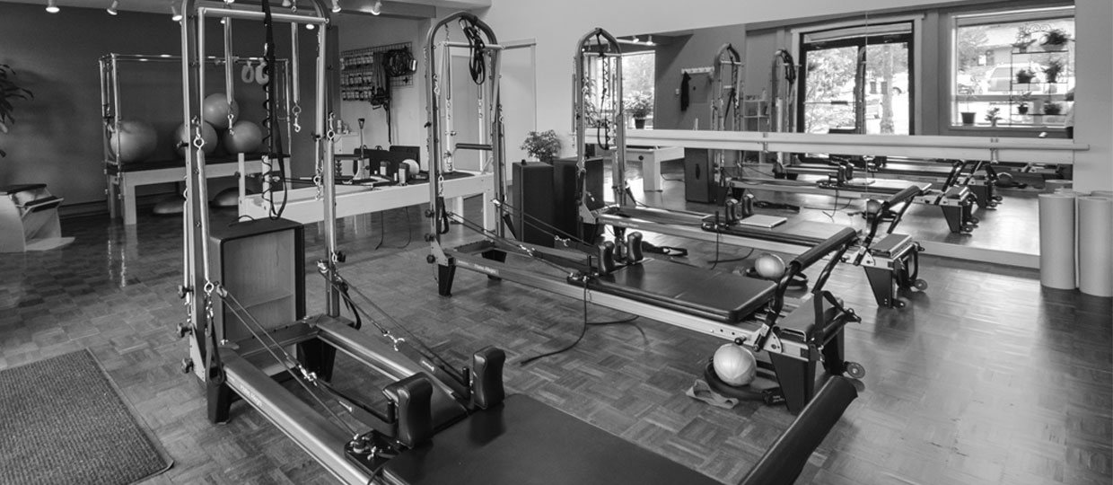 Inside the Pilates studio at Big Sky Fitness Fusion, with reformers and towers beneath the windows